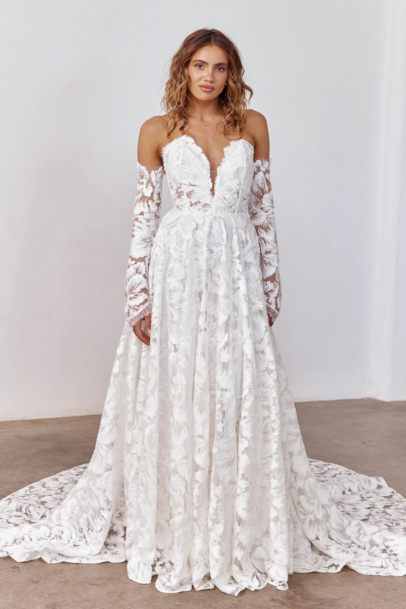 Woman wearing a strapless lace wedding dress with long sleeves_XS_