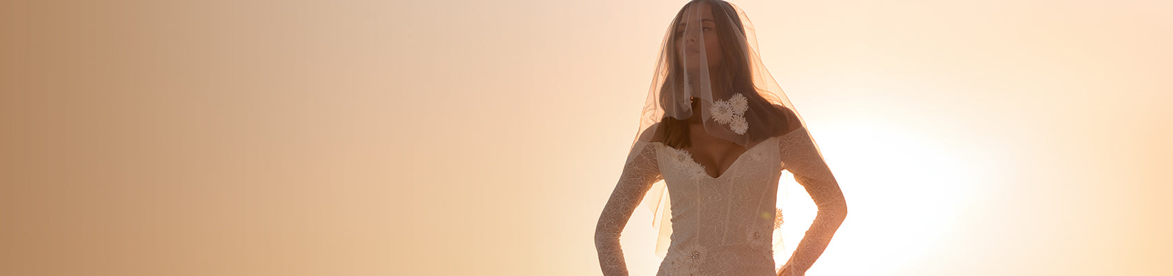 Bride in our Gigi wedding dress with a sunset behind her