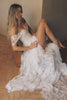 A woman wearing a white off-the-shoulder lace wedding gown with a deep V neckline and a full layered skirt_XS_