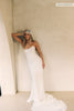 A woman wearing a strapless white wedding gown with a draped bodice and floor-length silhouette_xs_