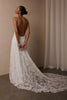 woman wearing a white lace backless dress with thin straps and delicate chain jewellery across her back