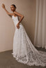 woman wearing a white lace backless dress with thin straps and delicate chain jewellery across her back