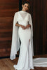 Woman wearing a white gown with a sheer white cape.