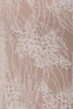 Close-up of a beige lace fabric with white floral embroidery and mesh backing.