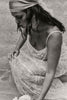Woman in a lace wedding dress and headscarf.