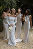 Woman in a lace wedding dress with three other women in champagne bridesmaid dresses.