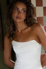 Woman wearing a white strapless dress with pearl drop earrings
