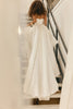 Woman walking up the stairs in a satin wedding dress